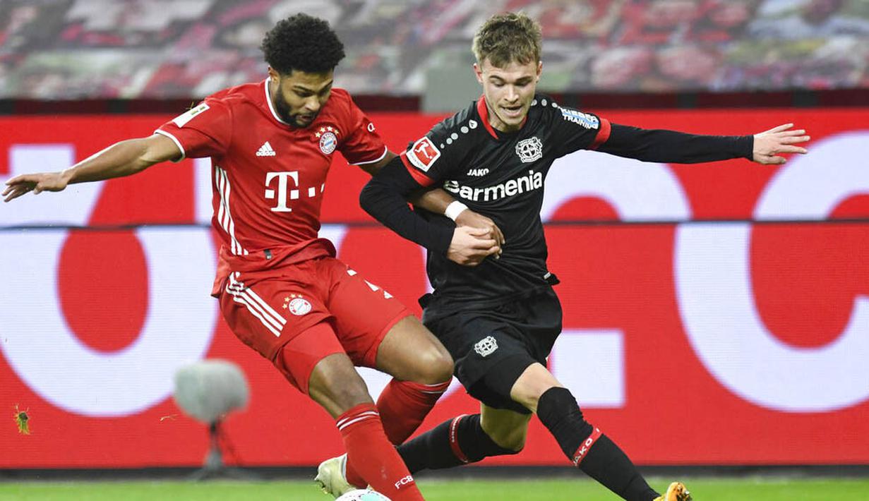 Penyerang Bayern Munchen, Serge Gnabry, berebut bola dengan pemain Bayer Leverkusen, Daley Sinkgraven, pada laga Bundesliga di Stadion BayArena, Minggu (20/12/2020). Bayern Munchen menang dengan skor 2-1. (Bernd Thissen/Pool Photo via AP)