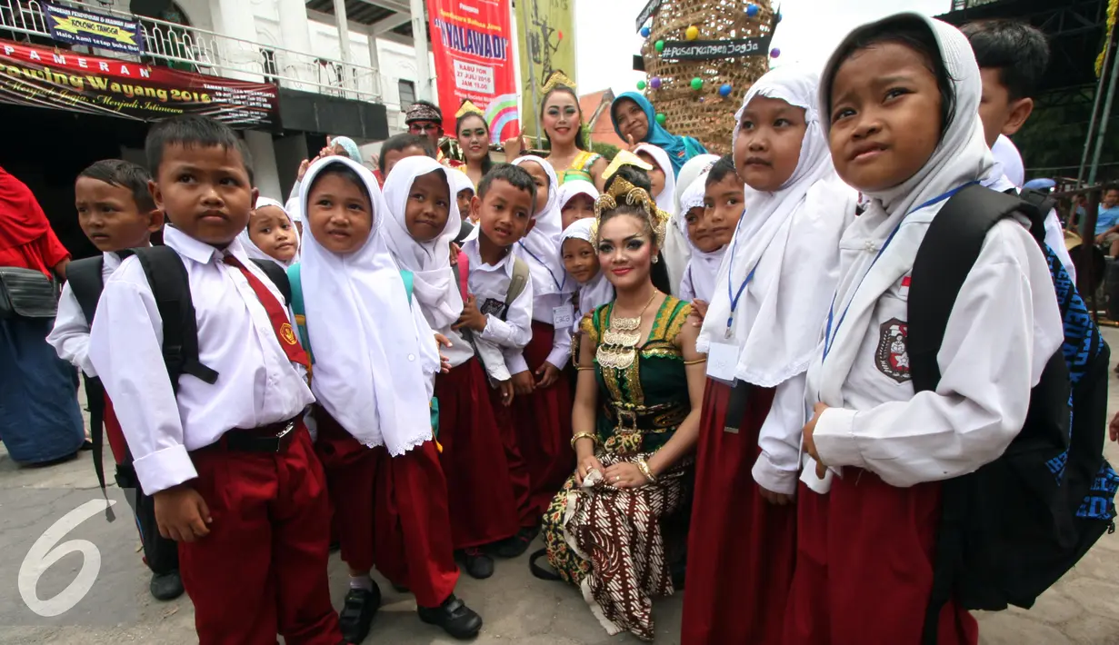 Sejumlah siswa SD berfoto dengan penari saat berkunjung ke Taman Budaya Yogyakarta, Rabu, (20/7). Beberapa sekolah di Yogyakarta melakukan MOS secara edukatif di antaranya dengan mengenalkan seni budaya kepada siswanya. (Liputan6.com/Boy Harjanto)  