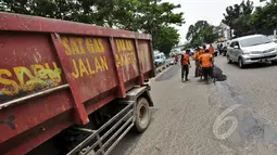 Sejumlah petugas mengaspal jalanan yang berlubang di Jalan Kramat Raya, Jakarta, Rabu (25/2/2015). Pascabanjir beberapa waktu lalu, sebanyak 700 titik lubang bermunculan di jalan Ibukota. (Liputan6.com/Faizal Fanani)