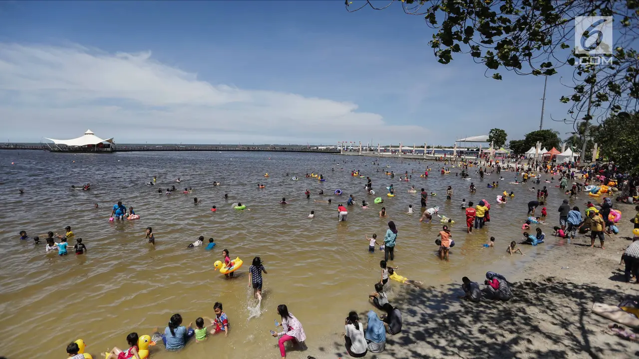 Libur Natal, Warga Menikmati Liburan Murah Meriah di Pantai Ancol