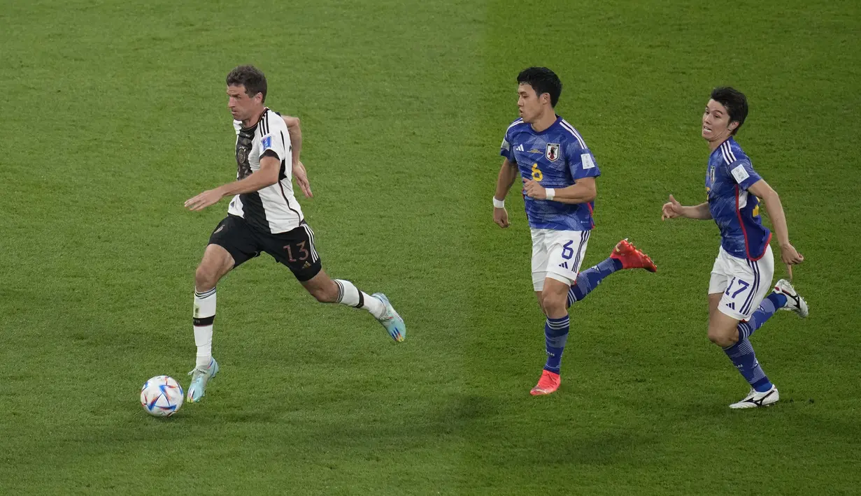 Penyerang Jerman, Thomas Mueller membawa bola dari kejaran dua pemain Jepang Wataru Endo dan Ao Tanakad selama pertandingan grup E Piala Dunia 2022 Qatar di Stadion Internasional Khalifa di Doha, Qatar, Rabu (23/11/2022). Jepang menang tipis atas Jerman dengan skor 2-1. (AP Photo/Ricardo Mazalan)