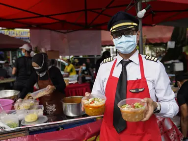 Mantan pilot Azrin Mohamad Zawawi menunjukkan mie laksa kari di warung makannya di Subang Jaya, Malaysia, Rabu (4/11/2020). Kapten Azrin, mantan pilot maskapai Malindo itu bersama 2.200 karyawan lainnya kehilangan pekerjaan usai di-PHK pada akhir Oktober akibat virus corona. (AP Photo/Vincent Thian)