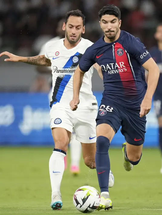 Pemain Paris Saint-Germain, Carlos Soler (kanan) berebut bola dengan pemain Inter Milan, Hakan Calhanoglu saat laga uji coba pramusim di Japan National Stadium, Tokyo, Jepang, Selasa (01/08/2023). (AP Photo/Hiro Komae)