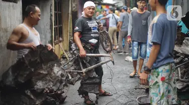 Warga membersihkan puing sisa kebakaran di kawasan padat penduduk di Jalan Kebon Jeruk 4, RT 004 RW 06, Kelurahan Maphar, Kecamatan Taman Sari, Jakarta, Jumat (7/2/2020). Sebanyak 29 unit mobil dikerahkan untuk melakukan pemadaman yang terjadi pada Kamis (6/2) malam. (Liputan6.com/Immanuel Antonius)