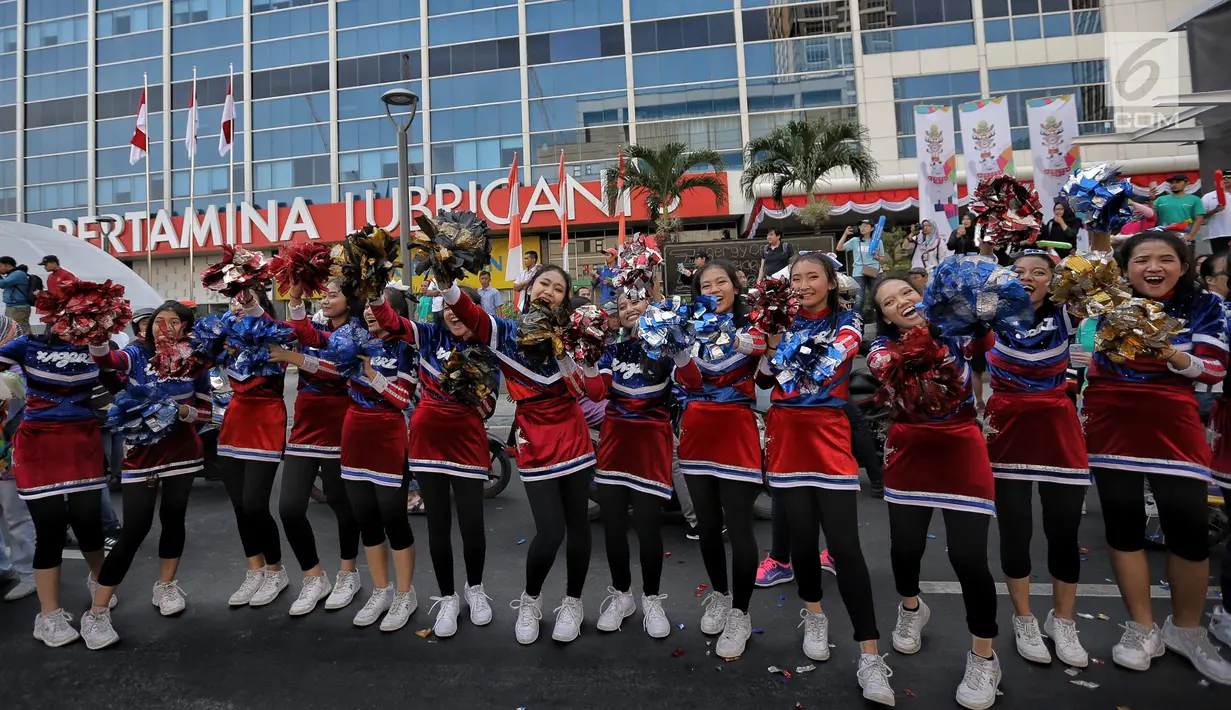 Pemandu sorak memeriahkan prosesi Torch Relay Asian Games 2018 di Jakarta, Sabtu (18/8). Hari ini merupakan puncak kirab obor Asian Games 2018 dimana api abadi akan berlabuh di Gelora Bung Karno (Liputan6.com/Faizal Fanani)