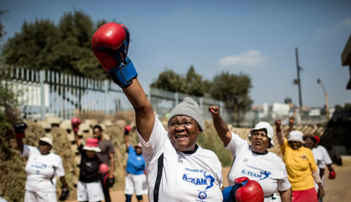 Sejumlah nenek melakukan pemanasan sebelum latihan tinju "Boxing Grannies" di Cosmo City di Johannesburg (19/9). "Boxing Grannies" adalah kelas tinju untuk nenek-nenek di Cosmo City. (AFP Photo/Gulshan Khan)