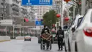 Warga mengenakan masker berjalan di sebuah jalan di Wuhan di provinsi Hubei tengah China (3/3/2020). Sejauh ini, total 80.026 kasus virus corona terkonfirmasi di wilayah China daratan. (AFP/STR)