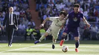 Pemain Real Madrid, Alvaro Odriozola, berusaha melewati pemain Celta Vigo pada laga La Liga 2019 di Stadion Santiago Bernabeu, Sabtu (16/3). Real Madrid menang 2-0 atas Celta Vigo. (AP/Paul White)