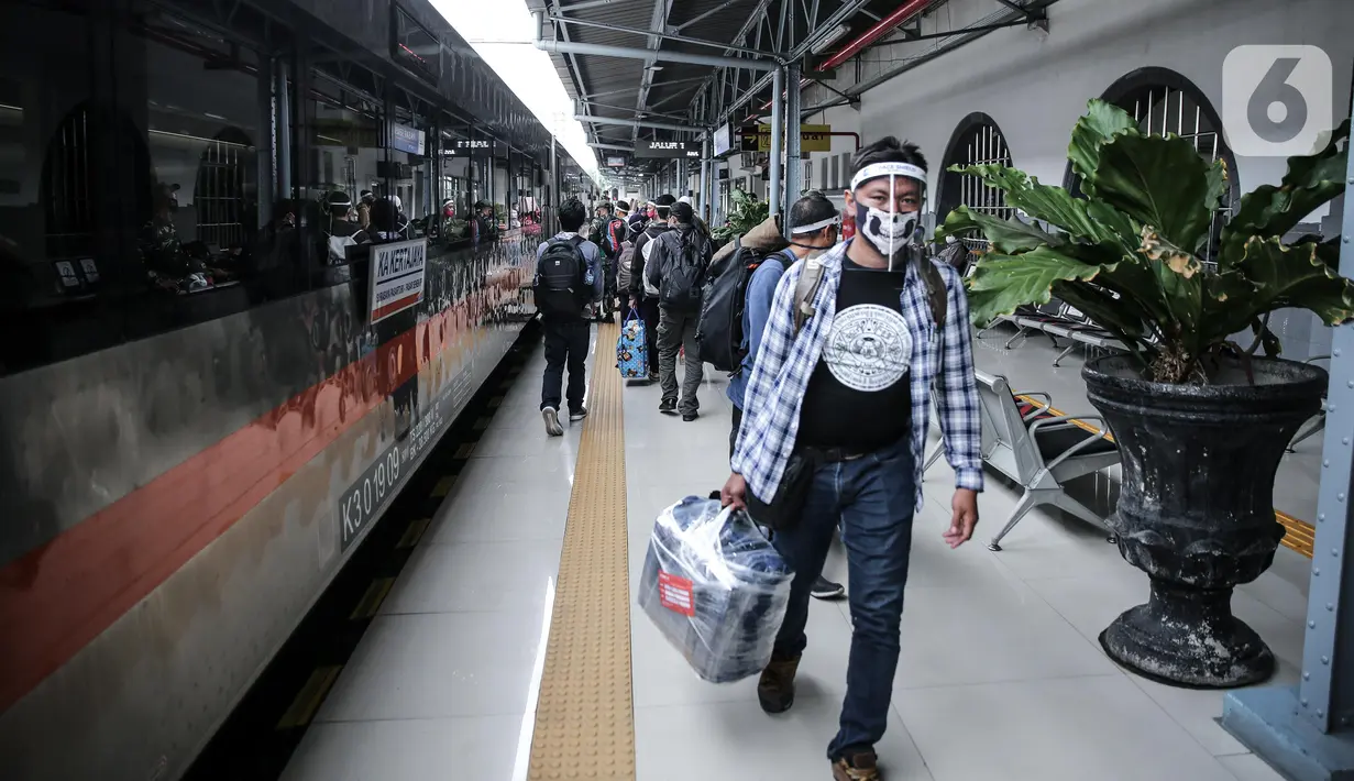 Penumpang menggunakan pelindung wajah berjalan di Stasiun Pasar Senen, Jakarta Pusat, Jumat (10/7/2020). PT. KAI membagikan face shield kepada penumpang bertujuan memudahkan masyarakat tetap dapat menjaga physical distancing di tengah pandemi COVID-19. (Liputan6.com/Faizal Fanani)