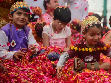 Anak-anak India bermain dengan kelopak bunga di sebuah acara untuk merayakan festival Hindu Holi untuk anak-anak cerebral palsy yang diselenggarakan oleh Yayasan Trishla di Allahabad (25/2). (AFP Photo/Sanjay Kanojia)