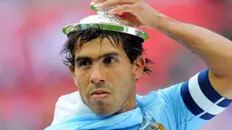 Striker Manchester City Carlos Tevez mengenakan tutup trofi FA Cup setelah The Citizens mengalahkan Stoke City 1-0 di partai final di Wembley Stadium, London, 14 Mei 2011.AFP PHOTO/ANDREW YATES