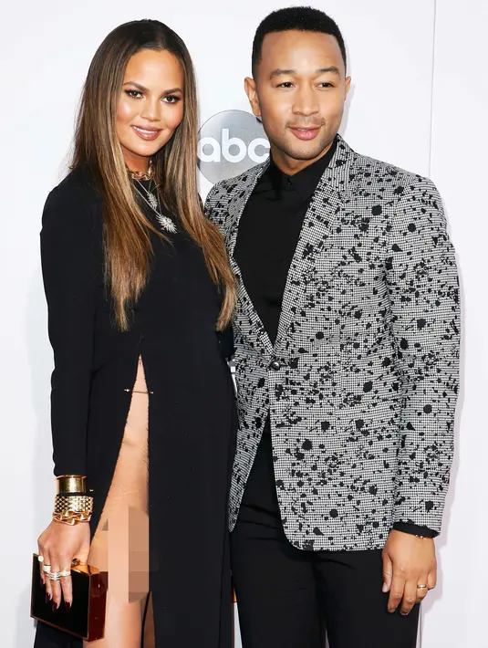 Model Chrissy Teigan menemani suaminya, John legend menghadiri American Music Awards (AMA) 2016 di Los Angeles, California, Minggu (20/11). Chrissy Teigen mengenakan gaun dengan belahan tinggi terbuka hingga ke payudara. (REUTERS/Danny Moloshok)