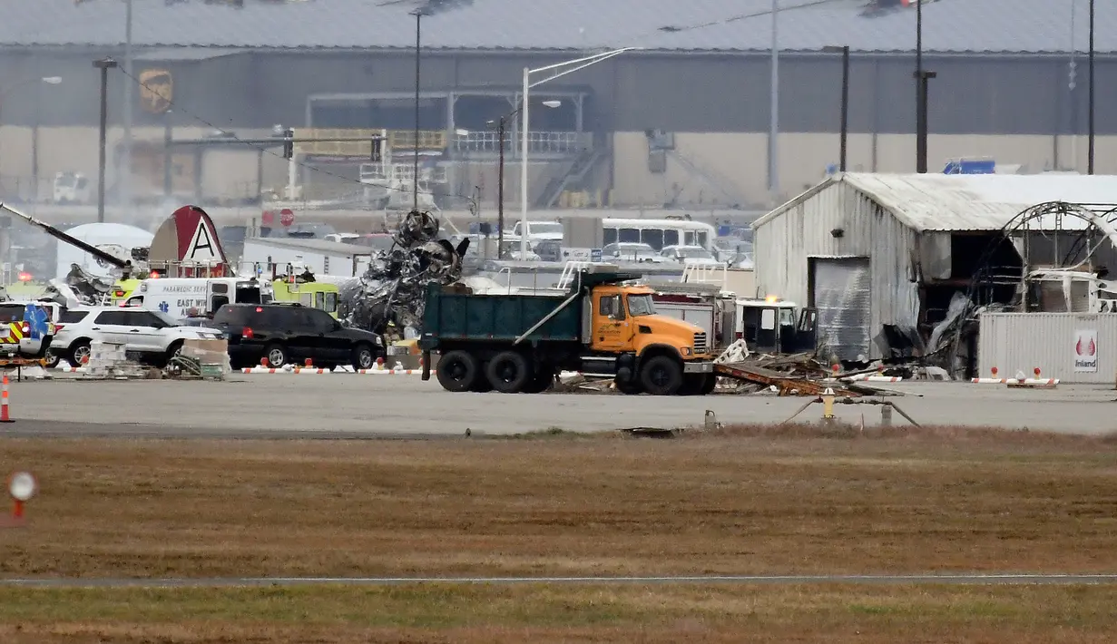 Operasi penyelamatan berlangsung di mana pesawat pengebom era Perang Dunia II milik Amerika Serikat jatuh di Bandara Internasional Bradley, Connecticut, Rabu (2/10/2019). Akibat insiden ini, setidaknya tujuh orang tewas. (AP Photo/Jessica Hill)