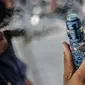 Seorang pria menggunakan vape atau rokok elektronik di kawasan Bundaran HI, Jakarta, Selasa (12/11/2019). Pemerintah melalui BPOM mengusulkan pelarangan penggunaan rokok elektrik dan vape di Indonesia, salah satu usulannya melalui revisi PP Nomor 109 Tahun 2012. (Liputan6.com/Faizal Fanani)