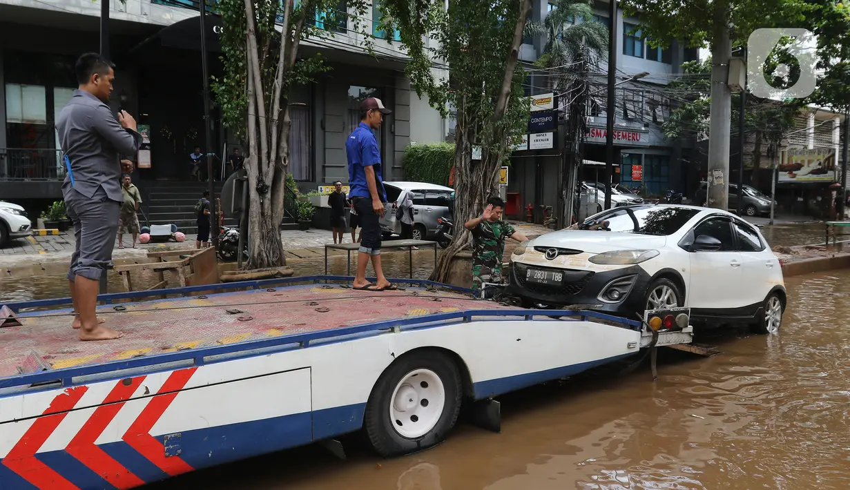 Sebuah mobil dipindahkan setelah terendam banjir di kawasan Kemang, Jakarta, Kamis (2/1/2020). Banjir yang melanda Jakarta dan sekitarnya mengakibatkan banyak kendaraan terendam air. (Liputan6.com/Herman Zakharia)