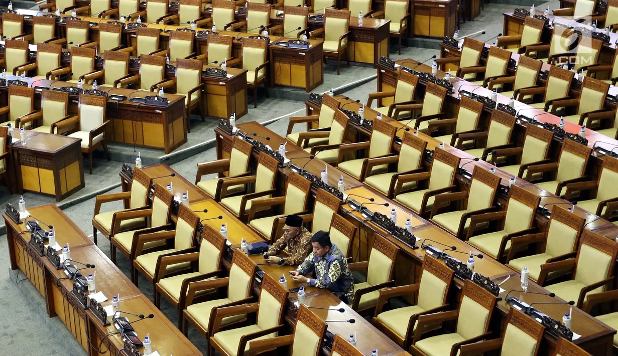Dua anggota DPR menghadiri rapat paripurna Masa Sidang I Periode 2019-2020 di antara bangku yang tak terisi di Kompleks Parlemen, Senayan, Jakarta, Kamis (22/8/2019). Rapat yang membahas RUU APBN Tahun 2020 beserta nota keuangannya itu hanya dihadiri 55 orang. (Liputan6.com/Johan Tallo)