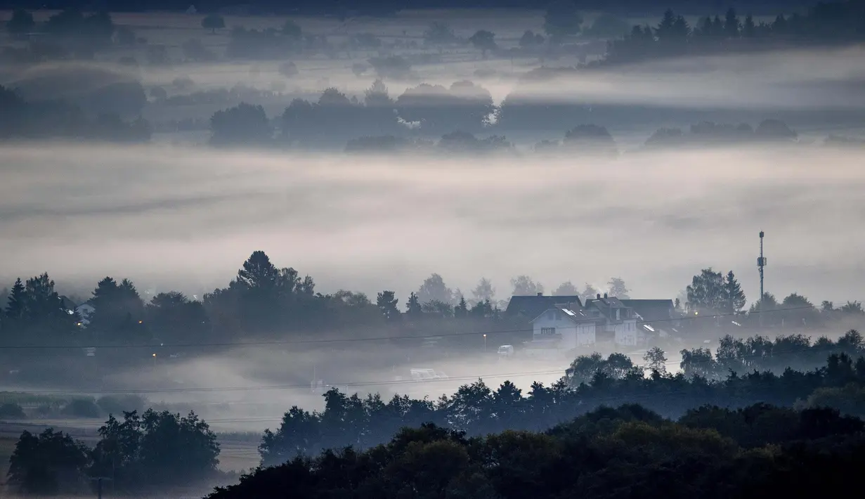 Kabut menyelimuti ladang dan kota Wehrheim dekat Frankfurt, Jerman, 19 Agustus 2020. (AP Photo / Michael Probst)