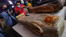 Sejumlah orang mengabadikan foto peti mati kuno yang baru ditemukan di situs pemakaman Saqqara di Provinsi Giza, Mesir, 3 Oktober 2020. Kementerian Pariwisata dan Kepurbakalaan Mesir memamerkan 59 peti mati kuno yang baru ditemukan dengan kondisi terawat baik di Provinsi Giza. (Xinhua/Ahmed Gomaa)