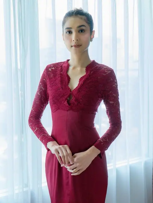 Saat akad nikah, Mikha tampil dengan dress merah yang memiliki detail brokat lengan panjang dengan bawahan kain merah polos. [@miktambayong]