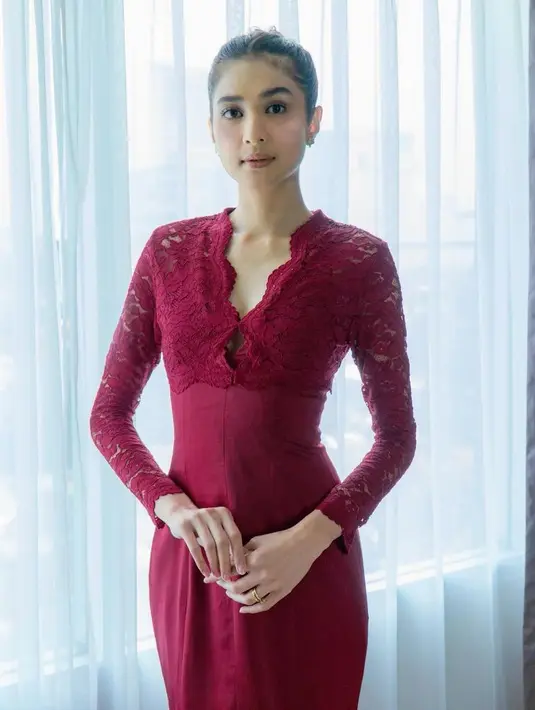 Saat akad nikah, Mikha tampil dengan dress merah yang memiliki detail brokat lengan panjang dengan bawahan kain merah polos. [@miktambayong]
