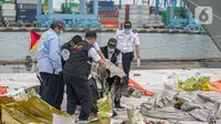 Petugas KNKT memeriksa bagian turbin pesawat Sriwijaya Air dihari kelima yang jatuh di perairan Pulau Seribu, di Dermaga JICT, Jakarta,  Rabu (13/1/2021). Potongan mesin jenis pesawat Boeing 737-500 yang ditemukan di perairan Kepulauan Seribu. (Liputan6.com/Faizal Fanani)