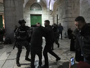 Polisi Israel menahan seorang jamaah Palestina di kompleks Masjid Al-Aqsa di Kota Tua Yerusalem selama bulan suci Ramadhan, Rabu, 5 April 2023. (AP Photo/Mahmoud Illean)