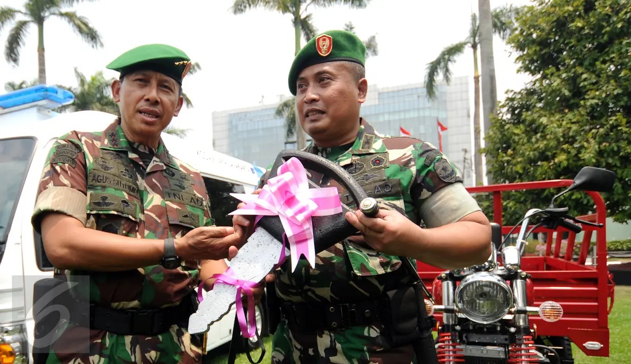 Komandan Kodiklat TNI AD, Letjen TNI Agus Sutomo (kiri) memberikan bantuan motor pengangkut kepada Kodim di lingkungan Kodam Jaya usai apel bersama Satuan Jajaran Kodam Jaya di Makodam Jaya, Jakarta, Kamis (17/9/2015). (Liputan6.com/Helmi Fithriansyah)