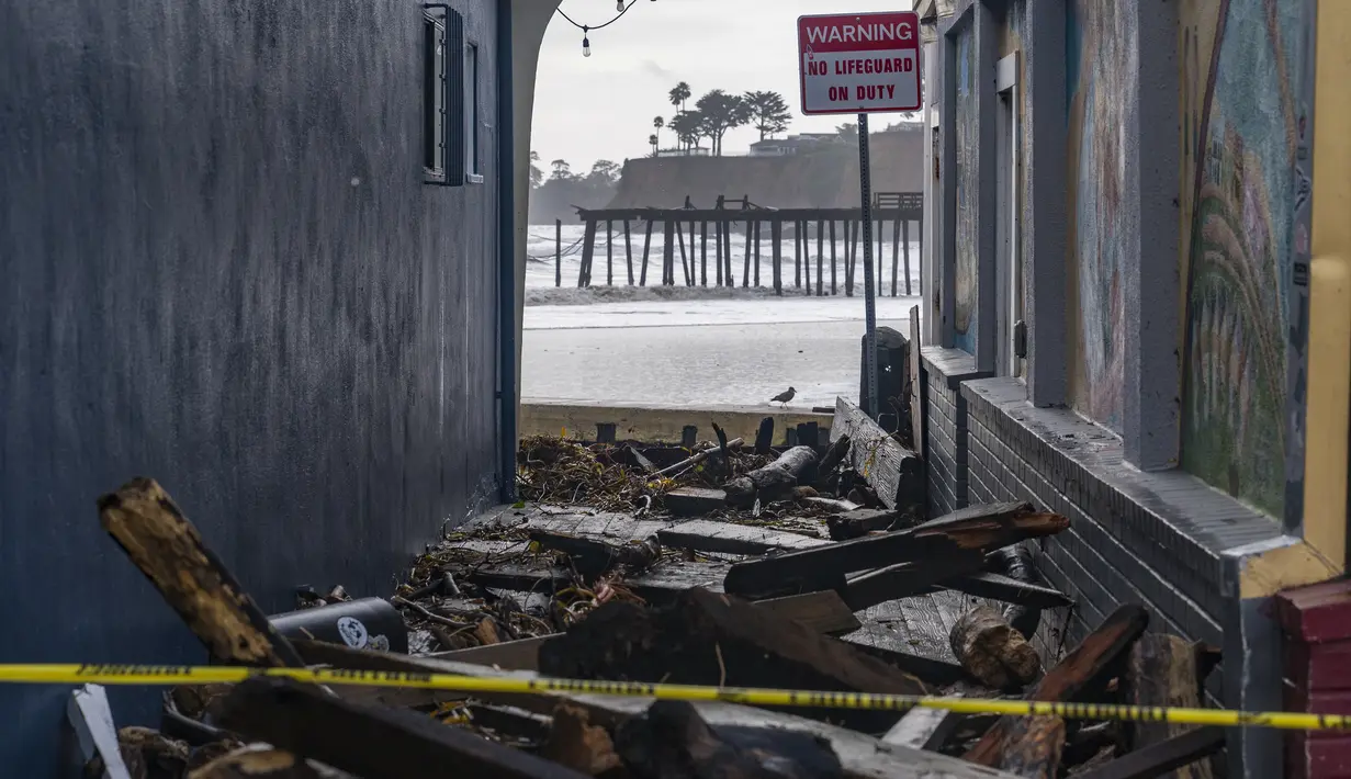 Puing-puing terlihat berserakan di gang setelah badai di Capitola, California, Kamis (5/1/2023). Angin topan yang merusak, ombak bergelombang dan hujan lebat dari "sungai atmosfer" yang kuat menghantam California pada hari Kamis, melumpuhkan puluhan ribu aliran listrik hingga menyebabkan banjir, dan mengakibatkan kematian setidaknya dua orang, termasuk seorang anak yang rumahnya dihantam pohon tumbang. (AP Photo/Nic Coury)