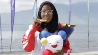 Atlet modern pentathlon, Dea Salsabila menunjukan medali usai meraih emas pada nomor beach triathle individual SEA Games 2019 di Subic, Jumat (6/12). Dirinya membukukan catatan waktu 00:19:52.73.  (Bola.com/M Iqbal Ichsan)