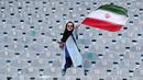 Wanita Iran mengibarkan bendera negaranya saat akan menyaksikan laga kualifikasi Piala Dunia 2022 antara Iran dengan Kamboja di Stadion Azadi, Teheran, Iran, Kamis (10/10/2019). Wanita Iran akhirnya diizinkan menonton bola dalam stadion setelah 38 tahun dilarang. (AP Photo/Vahid Salemi)