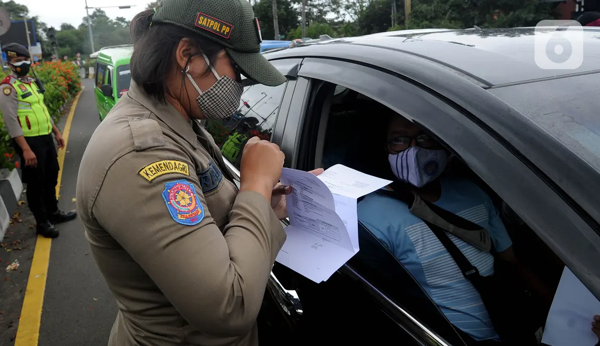 Petugas gabungan memeriksa surat hasil tes cepat antigen terhadap pengendara mobil di Simpang Gadog, Bogor, Kamis (24/12/2020). Pemkab Bogor mewajibkan para wisatawan menunjukkan hasil tes cepat antigen sebagai upaya mencegah penyebaran COVID-19 di saat libur Tahun Baru. (merdeka.com/Arie Basuki)