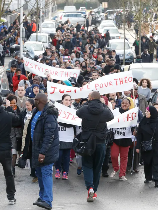 Pengunjuk rasa berdemo mencari keadilan untuk Theo di jalanan Aulnay-sous-Bois, utara Paris, Senin (6/2). Dokter menyebut, luka-luka yang diderita Theo tergolong parah hingga ia dinyatakan tidak boleh bekerja untuk 60 hari ke depan. (FRANCOIS GUILLOT/AFP)