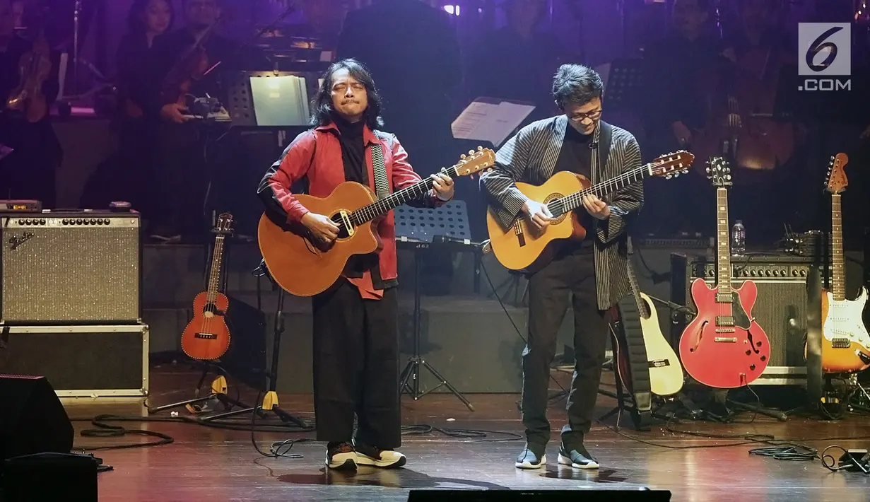 Dua gitaris terbaik Indonesia, Tohpati dan Dewa Budjana beraksi dalam konser mereka di Teater Jakarta, Taman Ismail Marzuki, Jumat (30/8/2019). Konser bertajuk "Janapati in Concert with Or­chestra" ini terbilang unik karena menampilkan musik instrumen gitar tanpa vokalis. (Fimela.com/Bambang E. Ros)