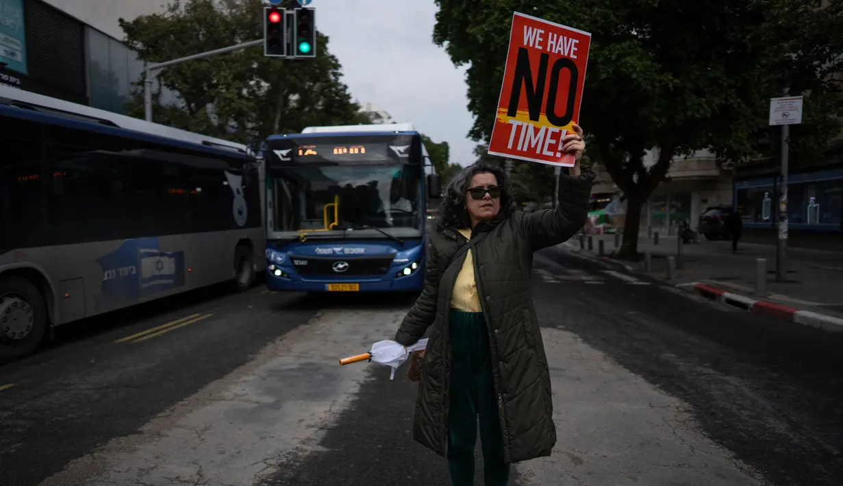 Mereka melakukan aksi protes sambil membentangkan poster di jalan. (AP Photo/Oded Balilty)