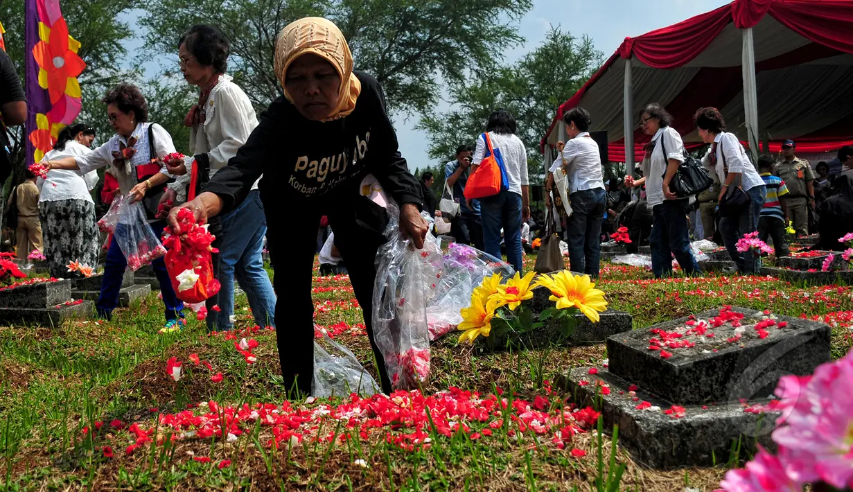 Keluarga korban Tragedi Mei 98 menaburkan bunga di makam sanak famili mereka yang menjadi korban Tragedi Mei 98 di TPU Pondok Ranggon, Jakarta Timur, Rabu (13/5/2015). (Liputan6.com/Yoppy Renato)