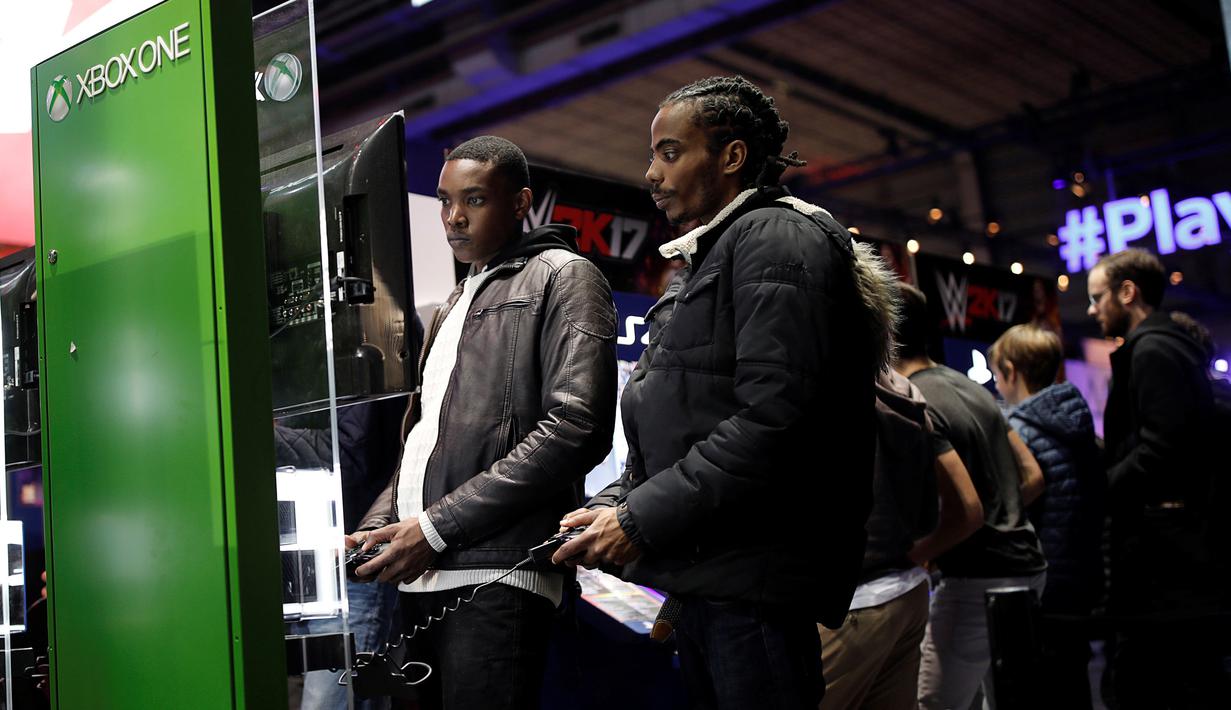 Dua pengunjung serius bermain Xbox One pada acara Paris Games Week di Paris, Prancis (26/10). Paris Games Week diselenggarkan pada 27–31 October. (REUTERS/Benoit Tessier)