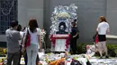Seorang fans berpose dengan foto Michael Jackson di depan pintu masuk makam di mana Jackson dikebumikan di Forest Lawn Memorial Park-Glendale, California, Rabu (25/6/14). (REUTERS/Kevork Djansezian)