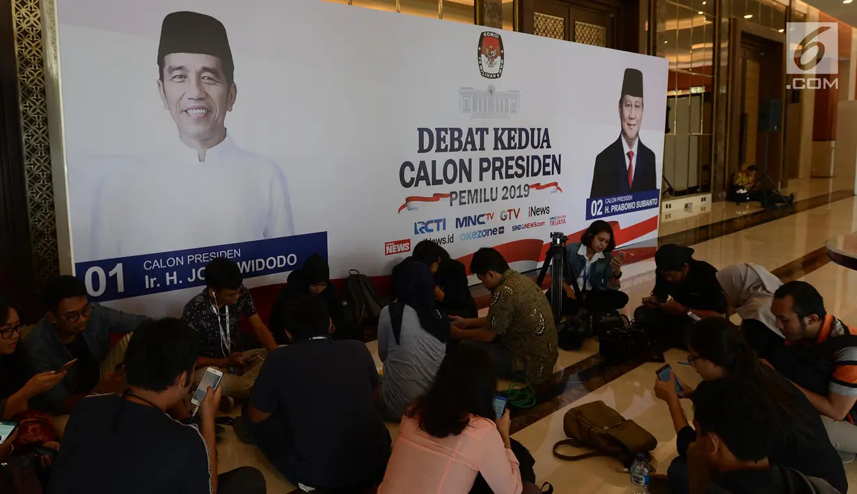 Sejumlah awak media beraktivitas jelang debat Capres kedua di Jakarta, Jumat (15/2). KPU mengusung materi debat kedua Capres 2019 mengangkat tema energi, pangan, infrastruktur, sumber daya alam, dan lingkungan hidup. (Merdeka.com/Imam Buhori)