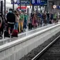 Penumpang berjalan di sepanjang peron di stasiun kereta utama di Frankfurt, Jerman, Jumat (14/8/2020). Mengenakan masker untuk melindungi diri dari corona Covid-19 adalah kewajiban di transportasi umum di Jerman. (AP Photo/Michael Probst)