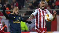 Striker Arsenal, Alexandre Lacazette (kiri) berebut bola dengan bek Olympiakos Piraeus, Ruben Semedo pada leg pertama babak 32 besar Liga Europa di Georgios Karaiskakis Stadium, Kamis (20/2/2020). Arsenal susah payah menaklukkan Olympiakos Piraeus 1-0. (ARIS MESSINIS / AFP)