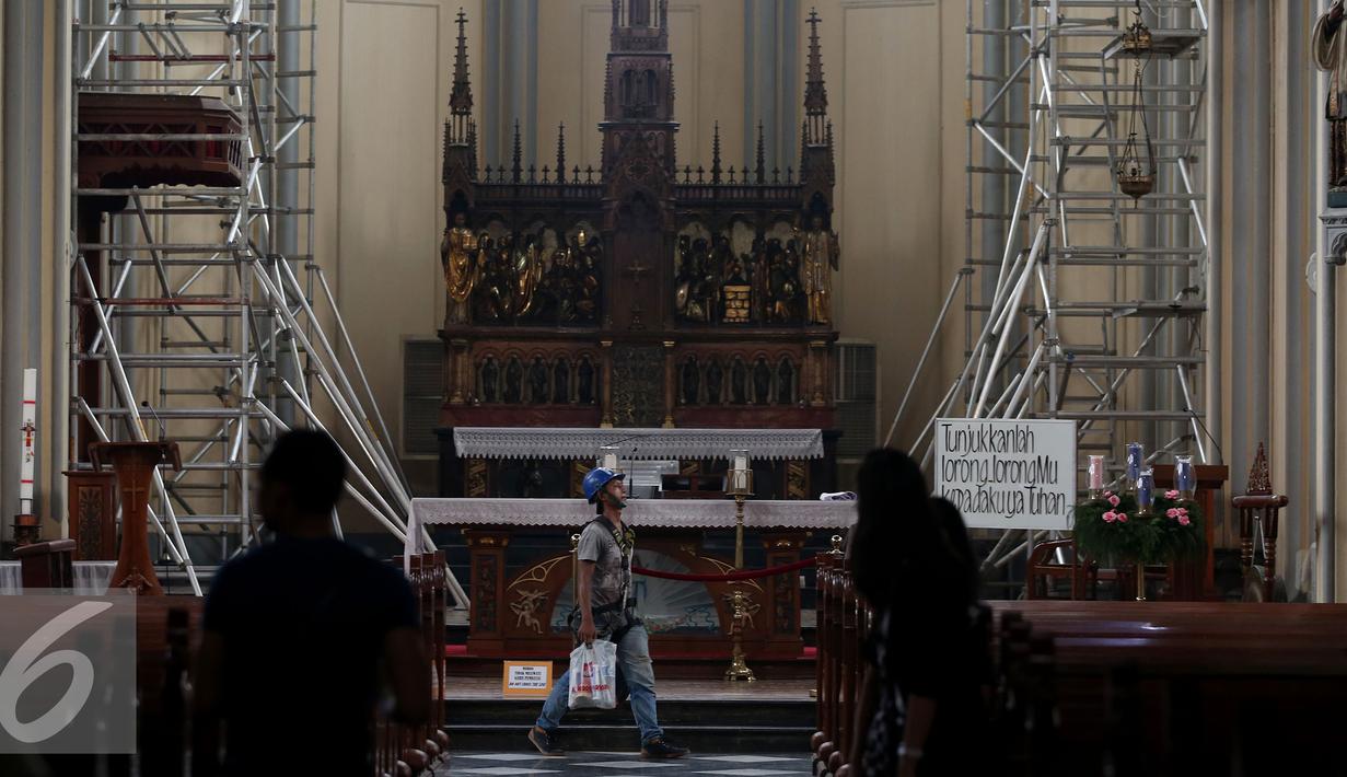 Pekerja berjalan di dalam Gereja Katedral saat bekerja membersihkan Gereja Katedral, Jakarta, Senin (12/12). Sejumlah persiapan dilakukan oleh pihak gereja untuk menyambut perayaan Natal. (Liputan6.com/Johan Tallo)
