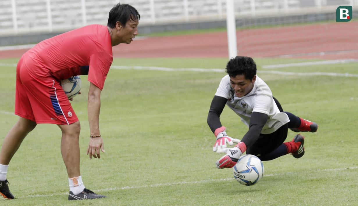 Kiper Timnas Indonesia, Muhammad Adi Satrio, menangkap bola saat sesi latihan di Stadion Madya, Jakarta, Selasa, (18/2/2020). Untuk meningkatkan performa kiper, Shin Tae-yong menambah porsi waktu latihan. (Bola.com/M Iqbal Ichsan)
