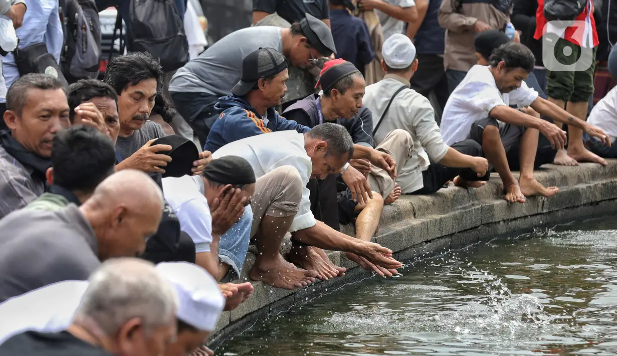 Massa mengambil wudhu dari air mancur di kawasan Patung Kuda, Jakarta Pusat. (Liputan6.com/Angga Yuniar)