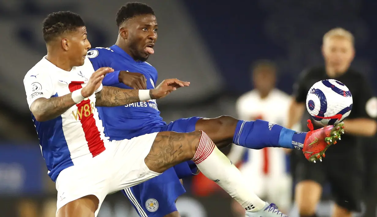Bek Crystal Palace, Patrick van Aanholt dan penyerang Leicester City, Kelechi Iheanacho berebut bola dalam lanjutan Premier League digelar di King Power Stadium, Selasa (27/4/2021) dini hari WIB. Leicester City memetik kemenangan penting 2-1 di kandang atas Crystal Palace (Andrew Boyers/Pool via AP)