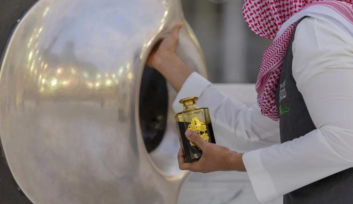 Seorang pria membubuhkan wewangian pada batu hajar aswad di sudut Ka’bah, Masjidil Haram, Makkah, Arab Saudi, Senin (27/7/2020). Karena pandemi COVID-19, Arab Saudi membatasi jumlah jemaah haji tahun ini hanya untuk sekitar 1.000 orang. (Saudi Ministry of Media via AP)