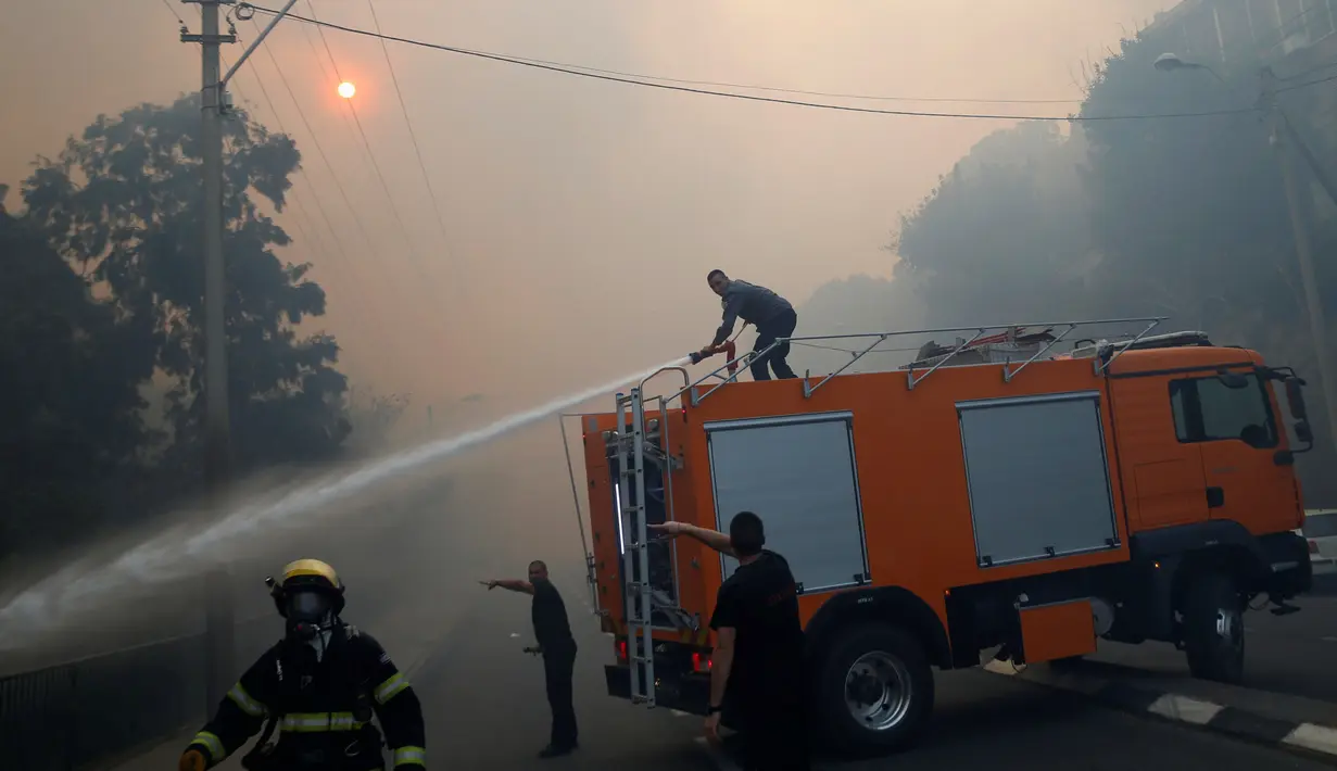 Kebakaran di wilayah Israel terus menyebar di sejumlah titik, Kamis (24/11). Angin kencang membuat api melahap lebih banyak area, terutama hutan-hutan di beberapa kota selama tiga hari, tepatnya sejak Selasa (22/11) lalu. (REUTERS / Baz Ratner)