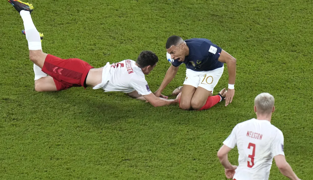 Bek Denmark, Andreas Christensen menjatuhkan penyerang Prancis, Kylian Mbappe selama pertandingan grup D Piala Dunia 2022 Qatar di Stadion 974 di Doha, Qatar, Sabtu, 26 November 2022. Prancis menutup laga kontra Denmark dengan skor 2-1 dan jadi tim pertama yang menembus 16 besar Piala Dunia 2022 Qatar. (AP Photo/Alessandra Tarantino)