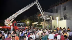 Warga berkumpul saat petugas pemadam berusaha mengevakuasi korban yang terjebak kebakaran  besar di rumah sakit SUM Bhubaneshwar di Odisha, India Timur, Senin (17/10). Sedikitnya 19 orang tewas dan sejumlah lainnya cedera dalam peristiwa tersebut. (AFP)