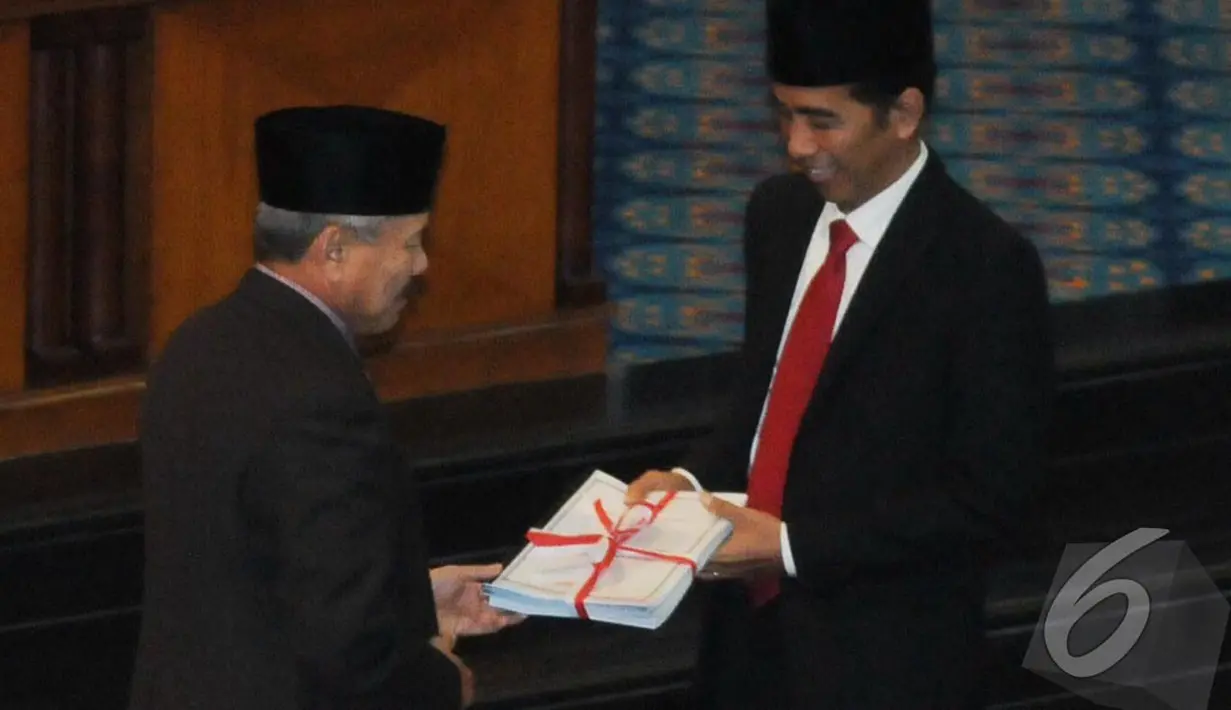 Jokowi menerima berkas yang diikat dengan pita merah putih saat menghadiri rapat paripurna di Dewan Perwakilan Rakyat Daerah (DPRD) DKI Jakarta, Jakarta, Rabu (23/7/14) (Liputan6.com/Herman Zakharia)