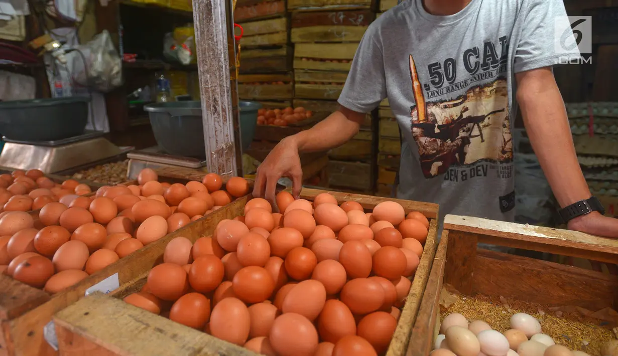 Penjual merapikan telur dagangannya di Pasar Minggu, Jakarta, Rabu (24/7). Harga telur ayam mengalami penurunan di angka Rp 26 ribu per kilo. (Merdeka.com/Imam Buhori)